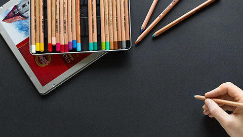 Hand holding a colored pencil.