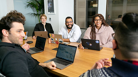 A group of office workers around a conference table.